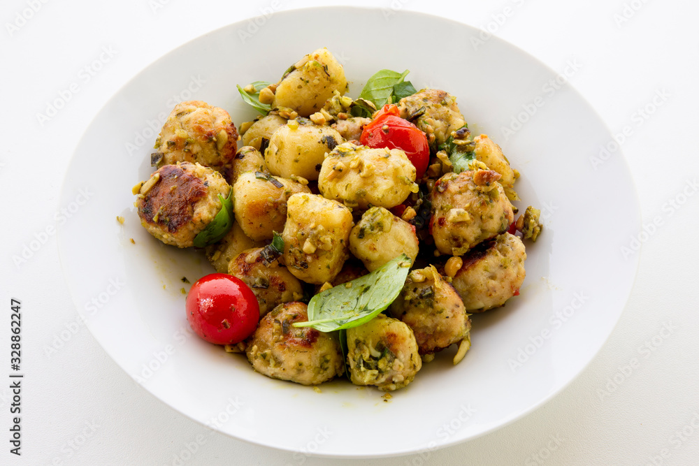 Gnocchi and chicken meatballs with pesto sauce, basil, tomatoes and nuts Gnocchi and chicken meatballs with pesto sauce, basil, tomatoes and nuts