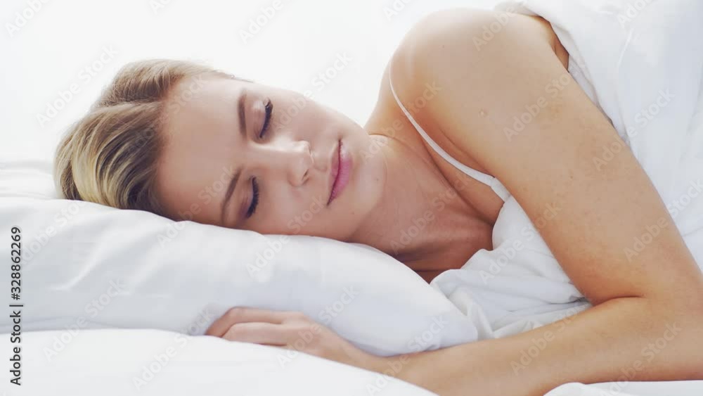 Young woman lying in the bed. Beautiful blond sleeping girl. Morning in the bedroom. Health and rest concept. Young woman lying in the bed. Beautiful blond sleeping girl. Morning in the bedroom. Health and rest concept.