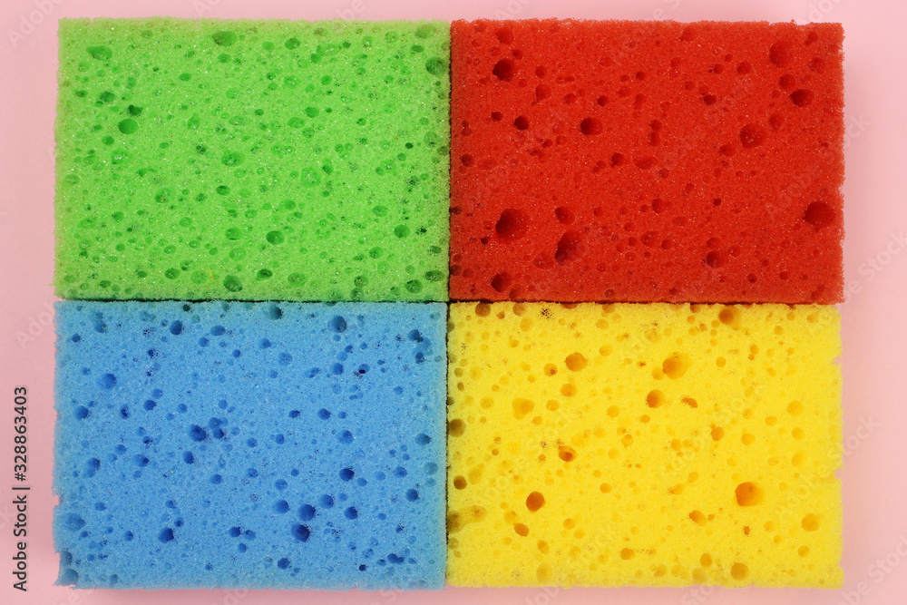 Background, texture of colored sponges for dishes or home cleaning on a pink background. The view from the top