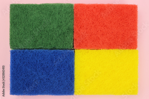 Background, texture of colored sponges for dishes or home cleaning on a pink background. The view from the top