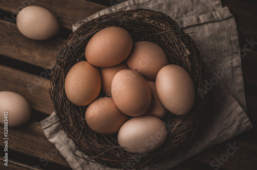 Organic eco eggs in nest on rustic table, Easter