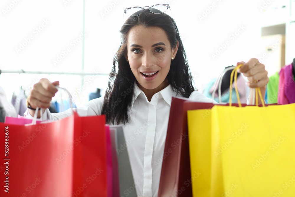 Stylish girl shows off packages with purchases. Pick up all things so that they fit well together and form convenient sets. Personal shopping consultant service. Corporate dress code. Stylish girl shows off packages with purchases. Pick up all things so that they fit well together and form convenient sets. Personal shopping consultant service. Corporate dress code.