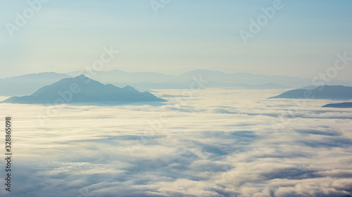 panoramic natural view of rang of mountain and green tree cover with sunrise morning fog with dramatic beauty nature sky.