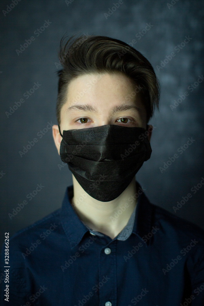 Portrait of a brown-eyed teenager in a black medical mask. Antivirus protection. Portrait of a brown-eyed teenager in a black medical mask. Antivirus protection.