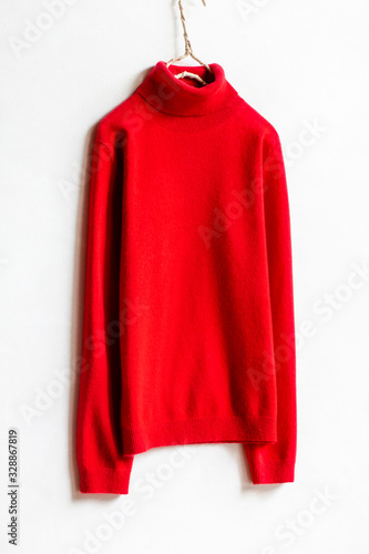 白バックとハンガーにかけた赤いタートルセーターのクローズアップ © minianne