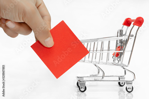Shopping cart and Post-red paper on white background.