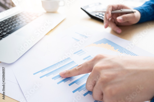 Businessman is inspecting and pointing at the business reports graphs to audit the financial reports. Analyzing the revenue and auditing the budget concept.