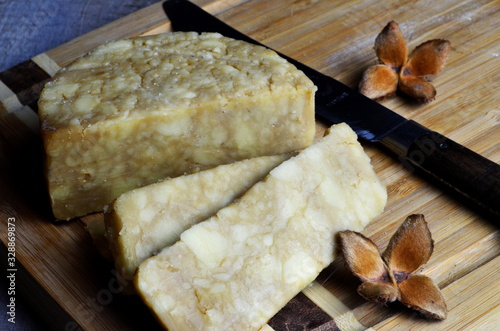 Canvas Print sliced guinness cheddar cheese on a wooden kitchen board