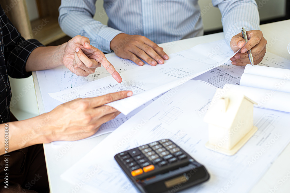 Engineers or architects are meeting a team to design the architectural structure in the design with blueprints and model buildings in working site, Technological structure and construction Concept. Engineers or architects are meeting a team to design the architectural structure in the design with blueprints and model buildings in working site, Technological structure and construction Concept.