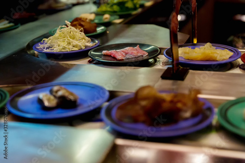 Japan restaurant food conveyor or belt buffet. belt sushi in japan restaurant with blurred background. photo