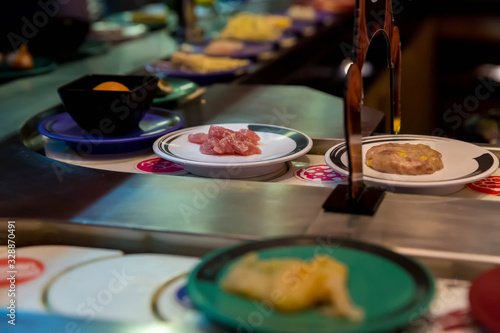 Japan restaurant food conveyor or belt buffet. belt sushi in japan restaurant with blurred background.