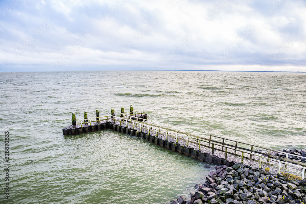 Stone pier by the Vlietermonument near Den Oever in Netherlands Stone pier by the Vlietermonument near Den Oever in Netherlands