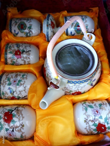 cup of tea.8 March 2020, Bangsar south, Kuala lumpur, Malaysia. A white tea set with colorful patterns in a yellow fabric box.