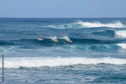 surfers in far distant over ocean waves. Blue horizontal landscape