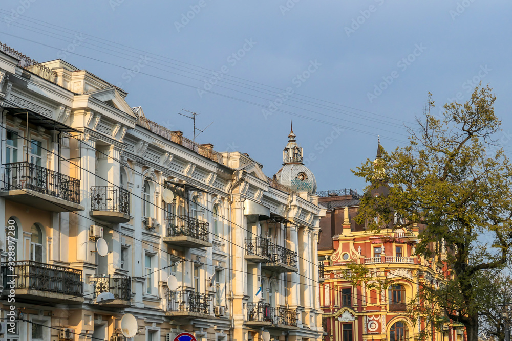 A row of old buildings captured during the golden hour in Kiev, Ukraine. Buildings have different colors, with detailed and ornate facade. Big city life.