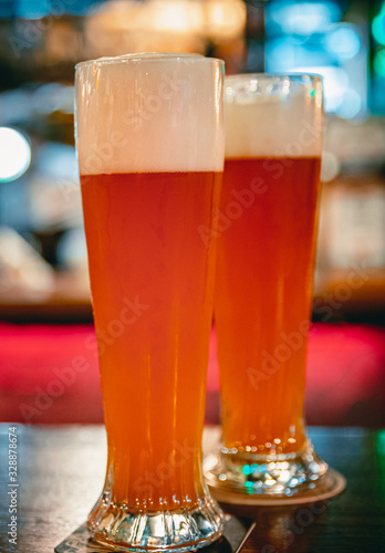 two glass of light beer stands on a table in a bar or pub