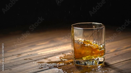 ice cube falling into glass of whiskey