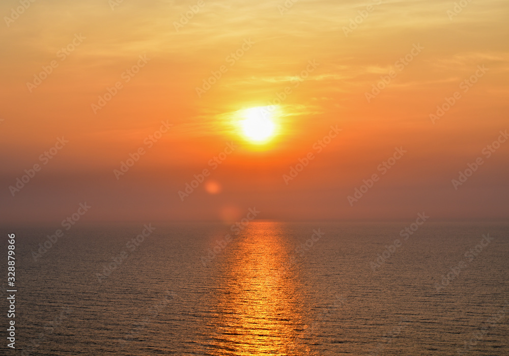 The orange reflections of the sun on the sea.