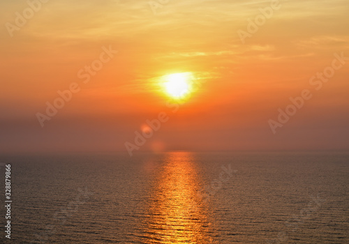 The orange reflections of the sun on the sea.