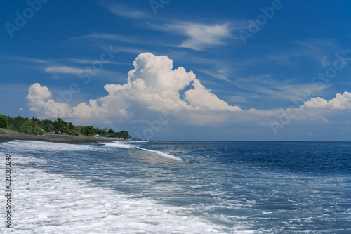 Black sand beach in Bali. Goa Lawah Beach. The wave rolls on the shore. photo