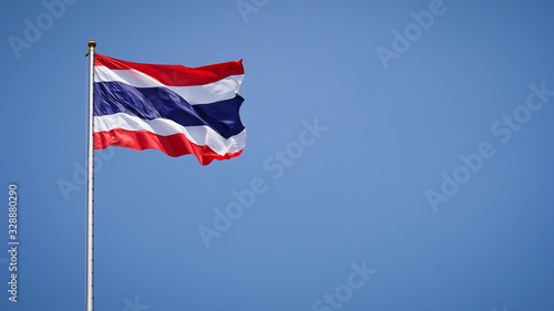 State national flag of Thailand waving on blue sky background.Free space on the side