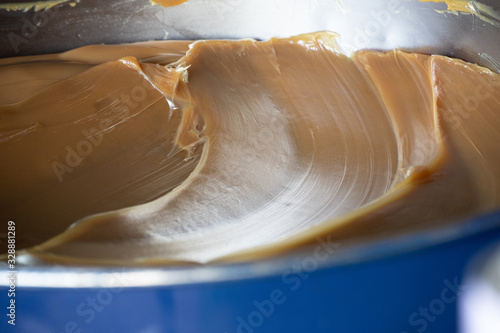 brown automotive grease in blue steel container. industry lubricants background. photo