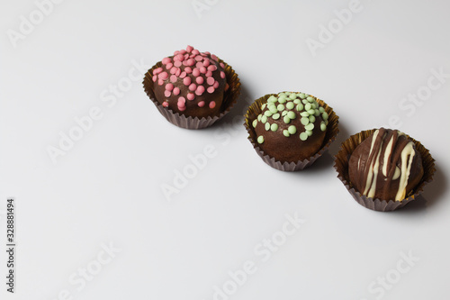 Chocolate Potato Cake. Some decorated with sprinkles, others with chocolate. On white background.