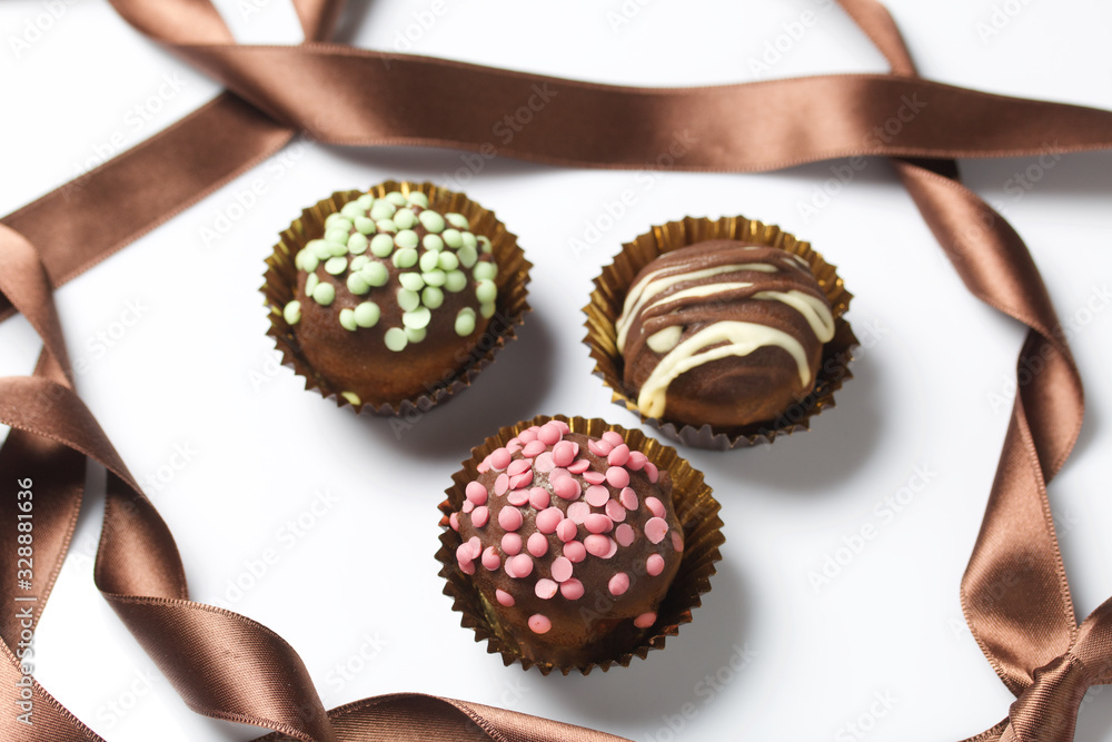 Chocolate Potato Cake. Some decorated with sprinkles, others with chocolate. On white background.