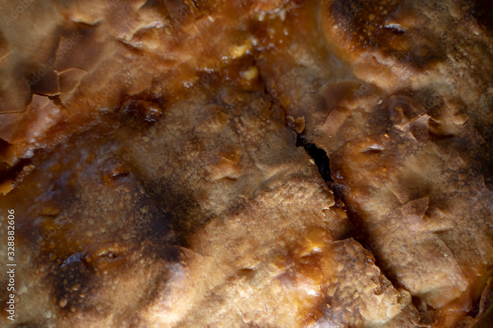 Pasty pie food texture. Extreme close-up of an empanada baked dough with cracks. Pasty pie food texture. Extreme close-up of an empanada baked dough with cracks.