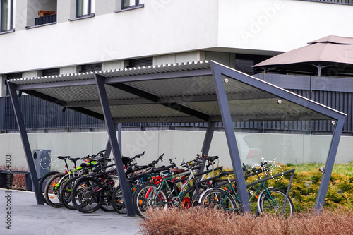 Modern Parking lot with a Bicycle roof near an apartment building with a large number of bicycles. Eco-friendly and sports transport in the city.