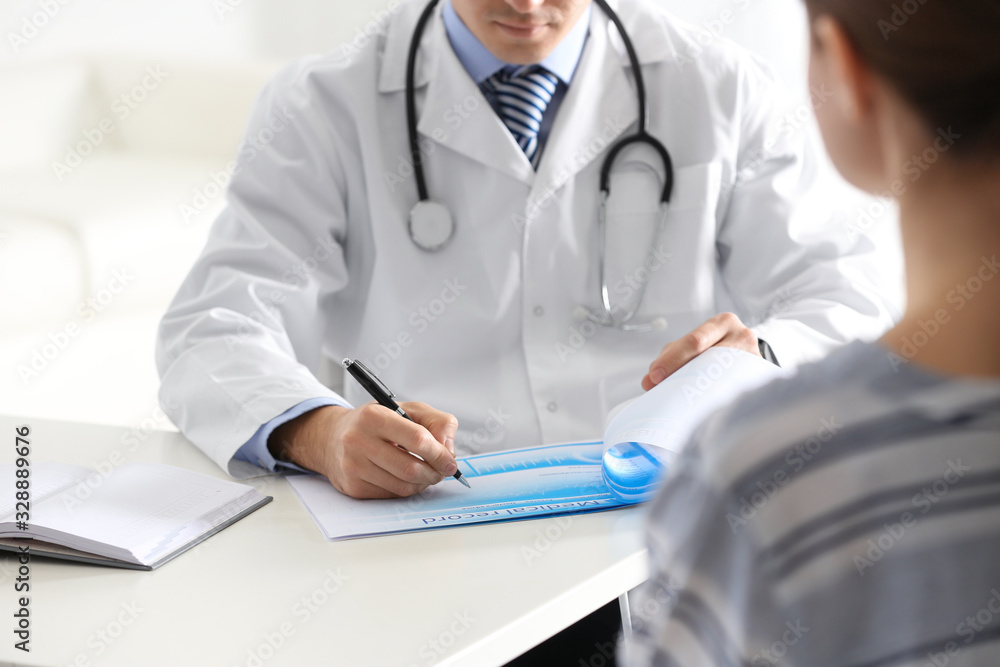 Doctor consulting patient at desk in clinic, closeup Doctor consulting patient at desk in clinic, closeup