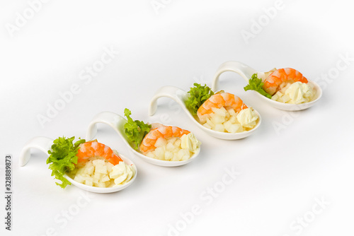 Snack with shrimp and apple in a glass boat on a white background