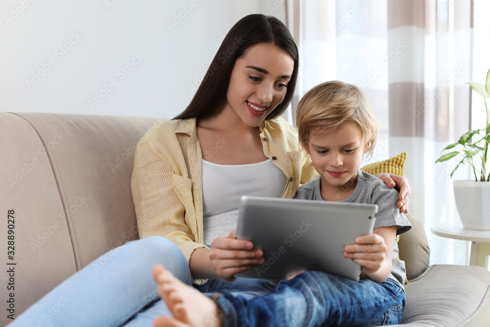 Mother and son reading E-book together at home Mother and son reading E-book together at home