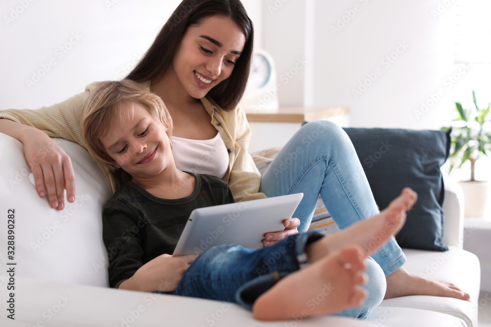 Mother and son reading E-book together at home Mother and son reading E-book together at home