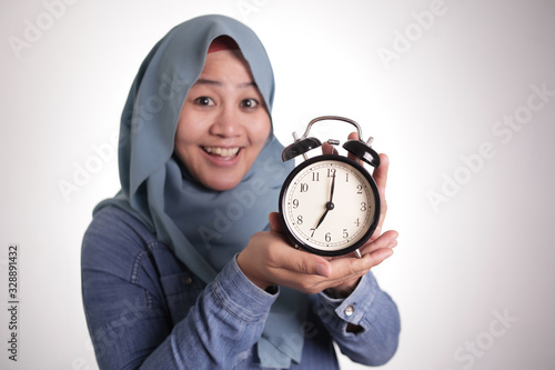 Muslim Woman Holding a Clock and Smiling, Time Management