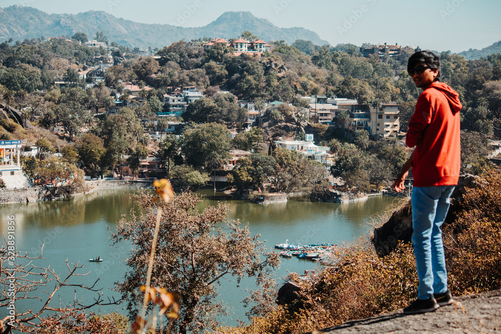 Portrait of an Indian man wearing sunglasses in front of the Nakki Lake in Mount Abu, Rajasthan, India