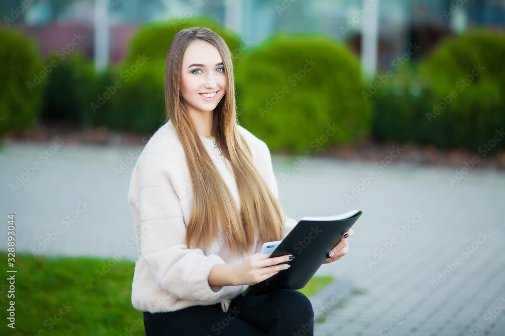 Obraz premium Business woman sitting on street near business center