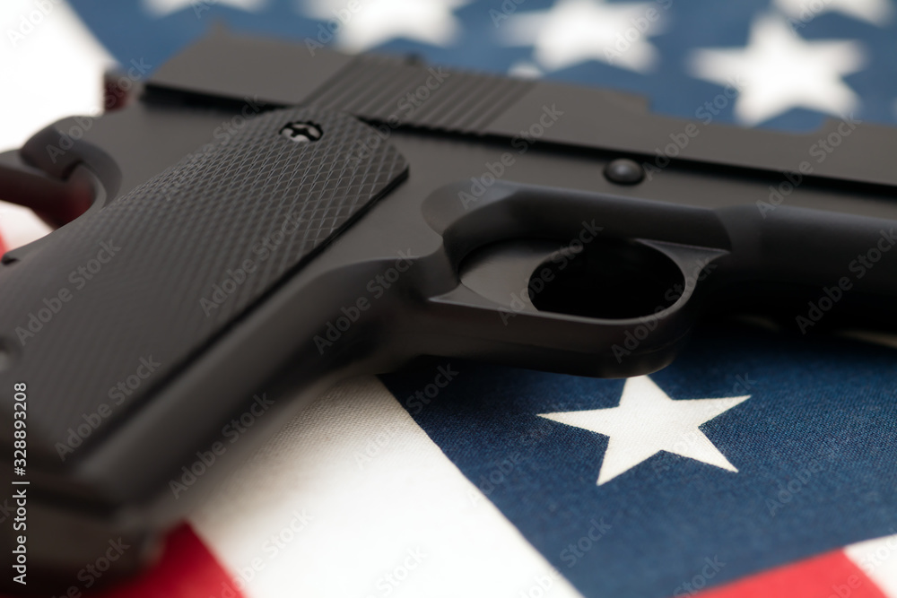 Semiautomatic pistol lying on American flag. Concept of gun culture