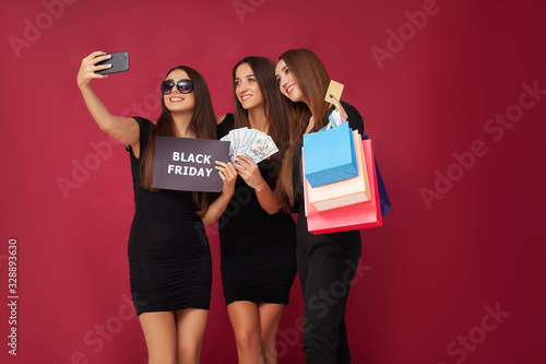 Women in black during black Friday sale on red background