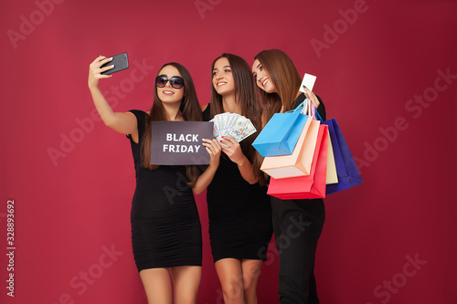 Women in black during black Friday sale on red background