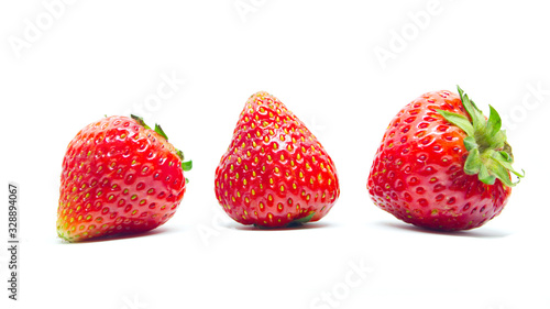 Side view of three  freesh straberries with leaf isolated on white background.
