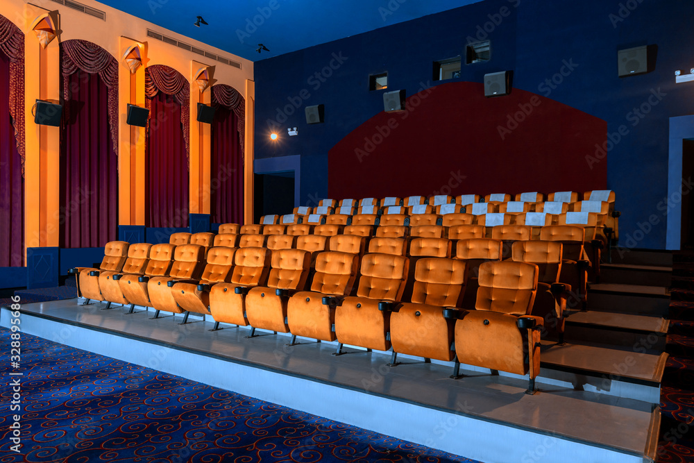Large cinema theater interior with seat rows for audience to sit in