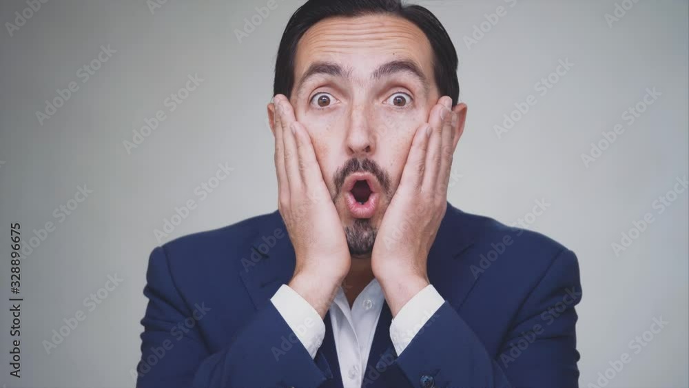 Surprised happy man is making faces. Man dressed in a blue suit, isolated on grey background. Close up. Action. Animation. 4K. Surprised happy man is making faces. Man dressed in a blue suit, isolated on grey background. Close up. Action. Animation. 4K.