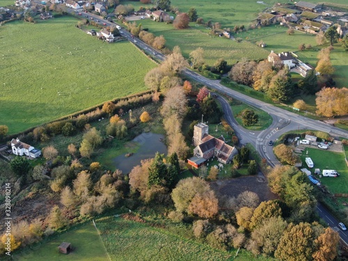 an aerial view of Saint Huberts church in Corfe Mullen in Dorset showing trees in the foreground photo