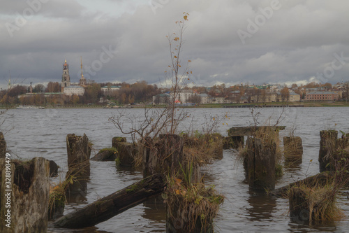 Ancient ruined pier of logs of the town of Kostroma. Boards and logs in the water. photo