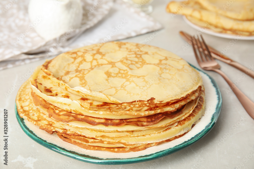 Stack of fresh thin pancakes on light grey marble table Stack of fresh thin pancakes on light grey marble table