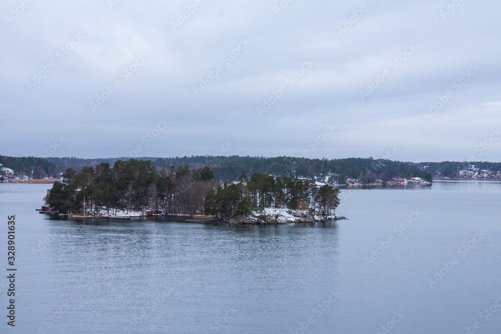An island with a few vacation houses near Stockholm, Sweden during a cold and gloomy winter morning.