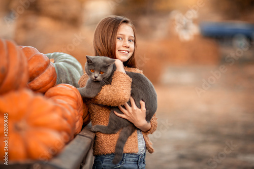 Girl with red hair on the street in the village near the pumpkin crop.