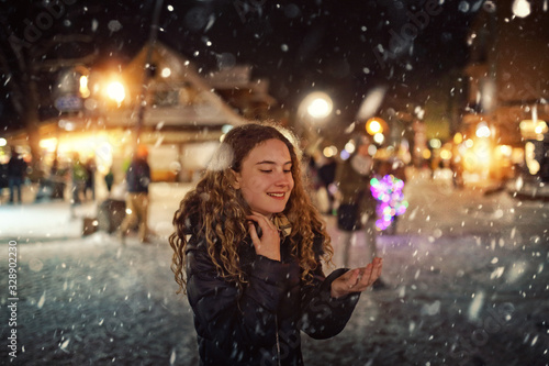 young girl enjoys and catches snow on her hand