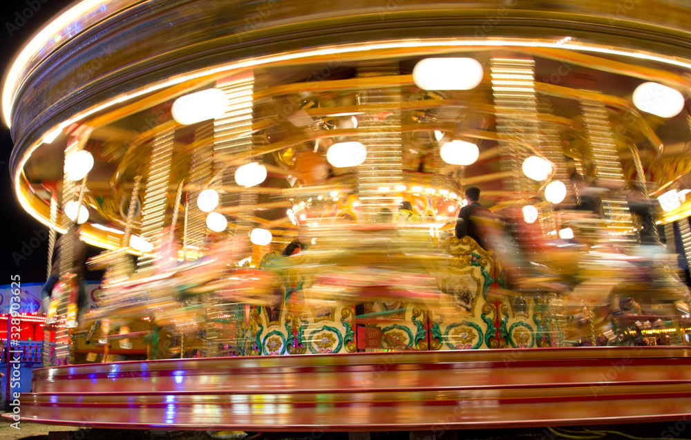 long exposure view of fairground ride at night with light trails and motion blur
